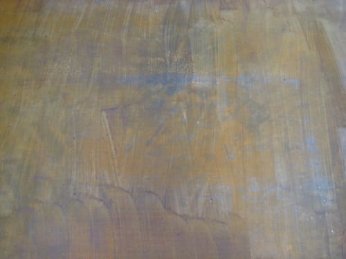 failed attempt at staining a darker brown color on concrete floor over a yellow stain floor with streaky results