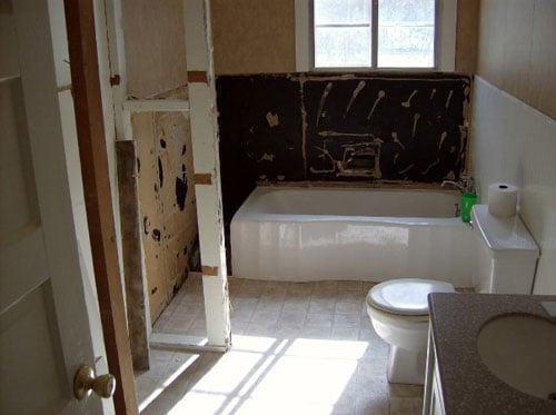 A Dark Blue Bathroom With A Corner Shower