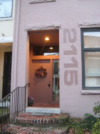 A Large Painted House Number On A Brick House