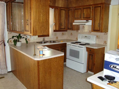 A Kitchen With A Dark Wood Island And White Cabinets