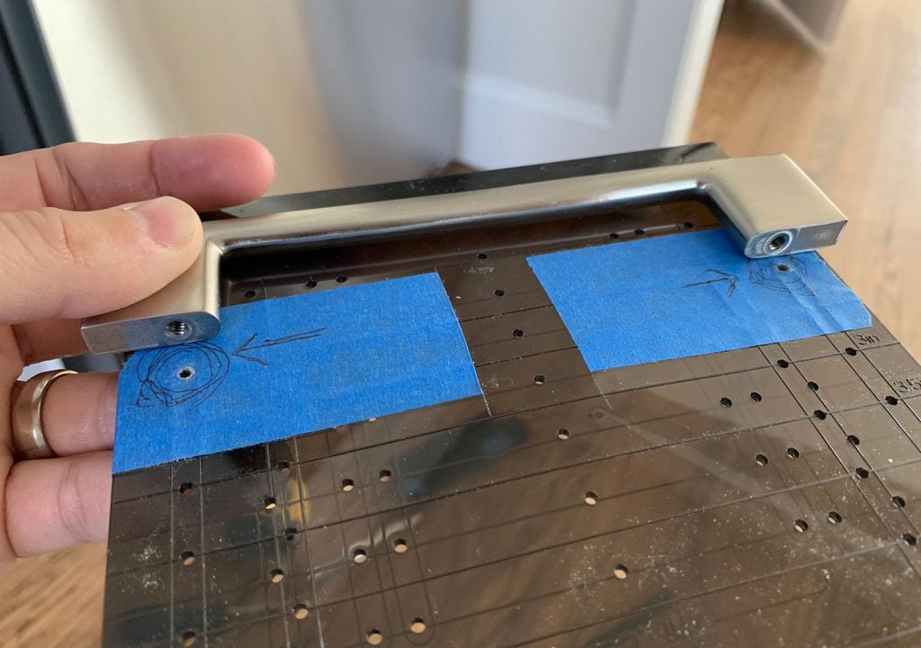 Cabinet Hardware Template Lined Up With Holes On Pull