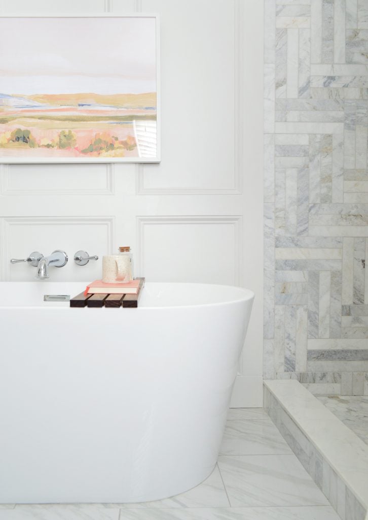 Freestanding tub side view in modern bathroom with marble shower