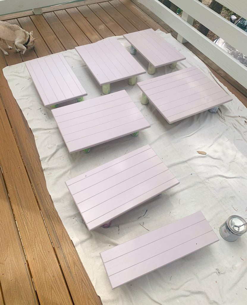 Wood cabinet doors on drop cloth drying with coat of mauve paint
