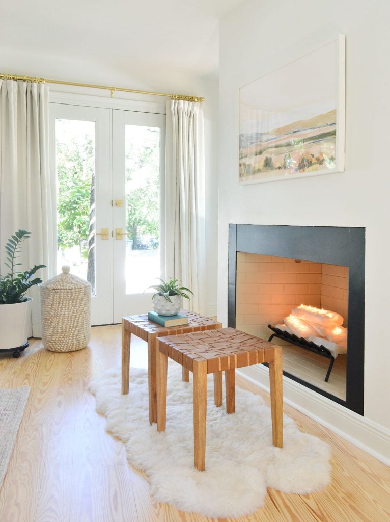Bedroom fireplace with white crystal logs stacked like firewood and candles lit