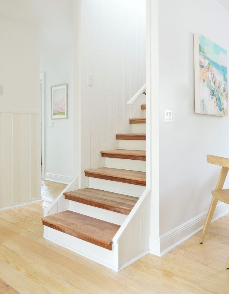 Bare wood stairs in white house
