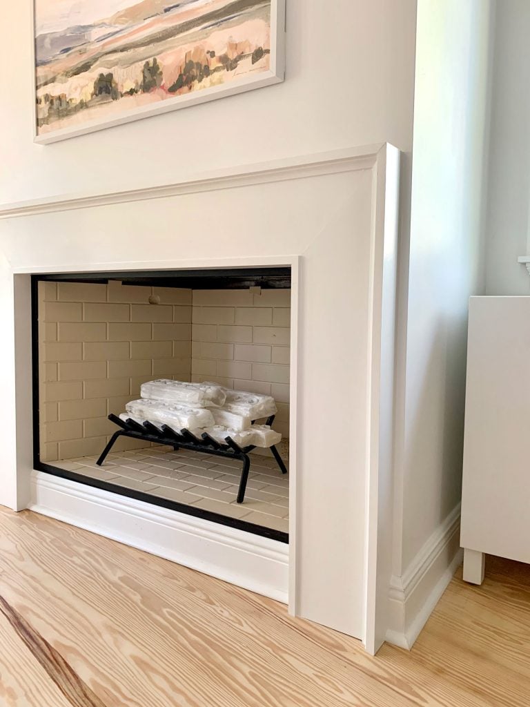 Closer view of fireplace surround showing about an inch of drywall between it and corner of wall