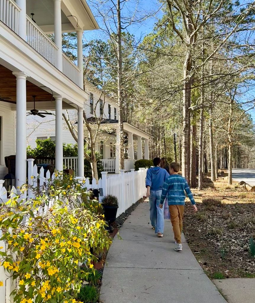 Family Walking Past Homes In Serenbe Georgia