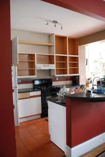 A White Kitchen With Black Counters And Open Shelves