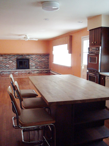 A Classic Kitchen With A Granite Island And White Glass Cabinets