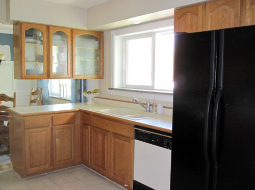 A Kitchen With Glass Cabinets, Wood Counters & A Marble Backsplash