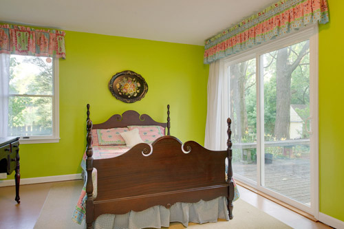 A Dark Gray Nursery With A Tree Mural & Striped Curtains