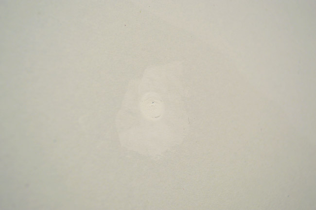 screw head with dried joint compound over it that has shrunk slightly