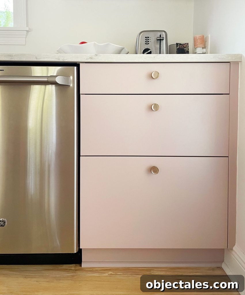 Completed Ikea kitchen with painted drawer fronts and brass knobs