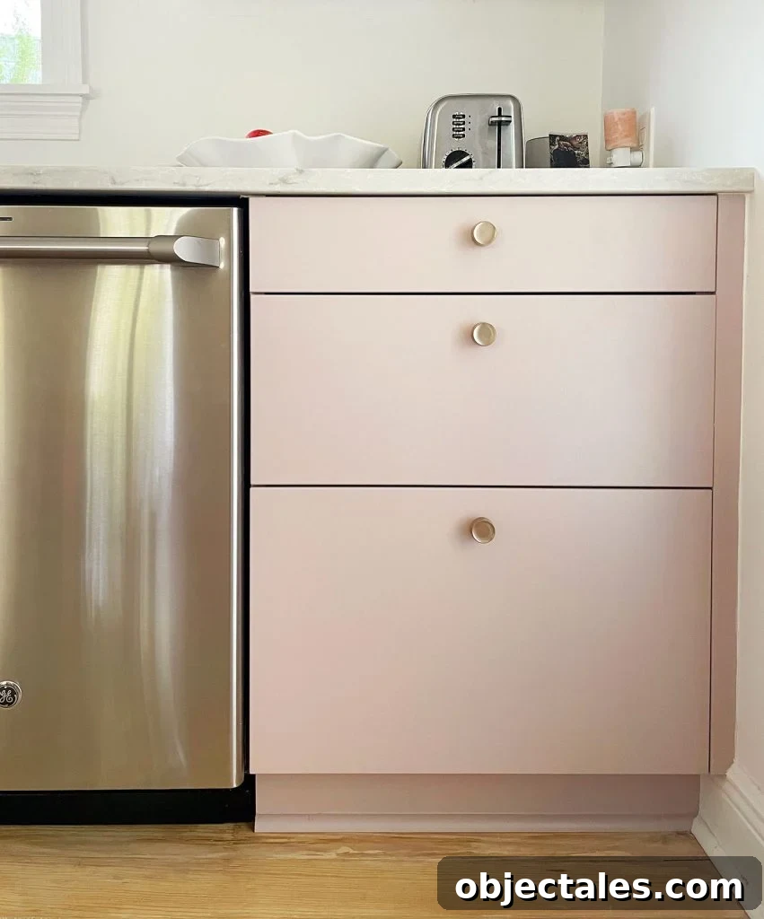 Completed Ikea kitchen with painted drawer fronts and brass knobs