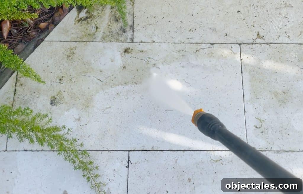 Spraying Pool Patio Stone With Electric Pressure Washer To Remove Scum