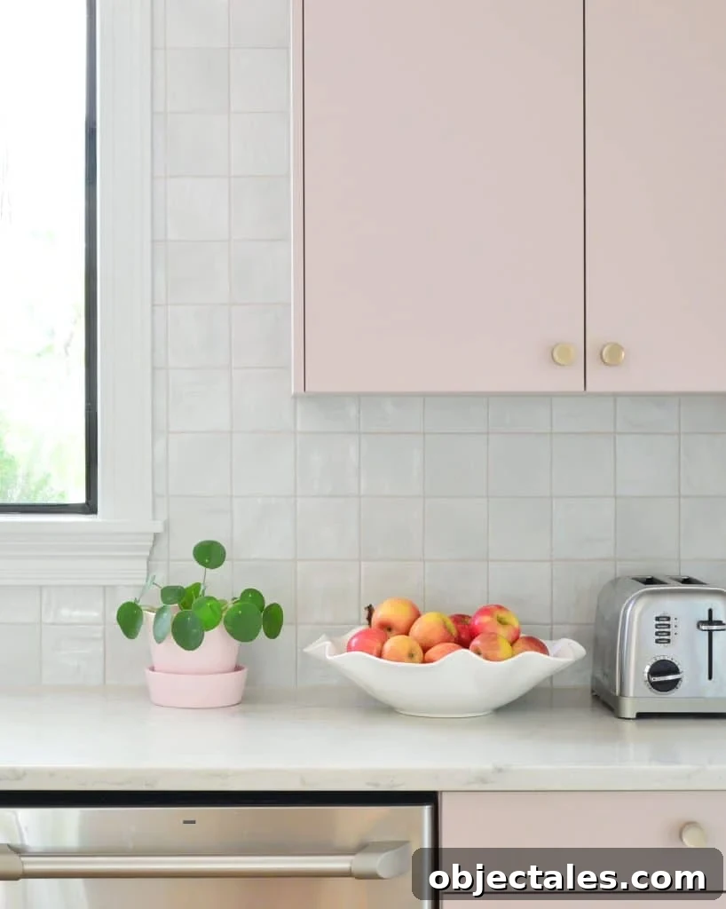 Square Tile Backsplash With Mauve Pink Painted Cabinets And Fruit Bowl