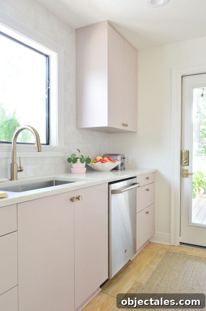 Angled View Of Painted Mauve Pink Kitchen Cabinets With Gray Backsplash