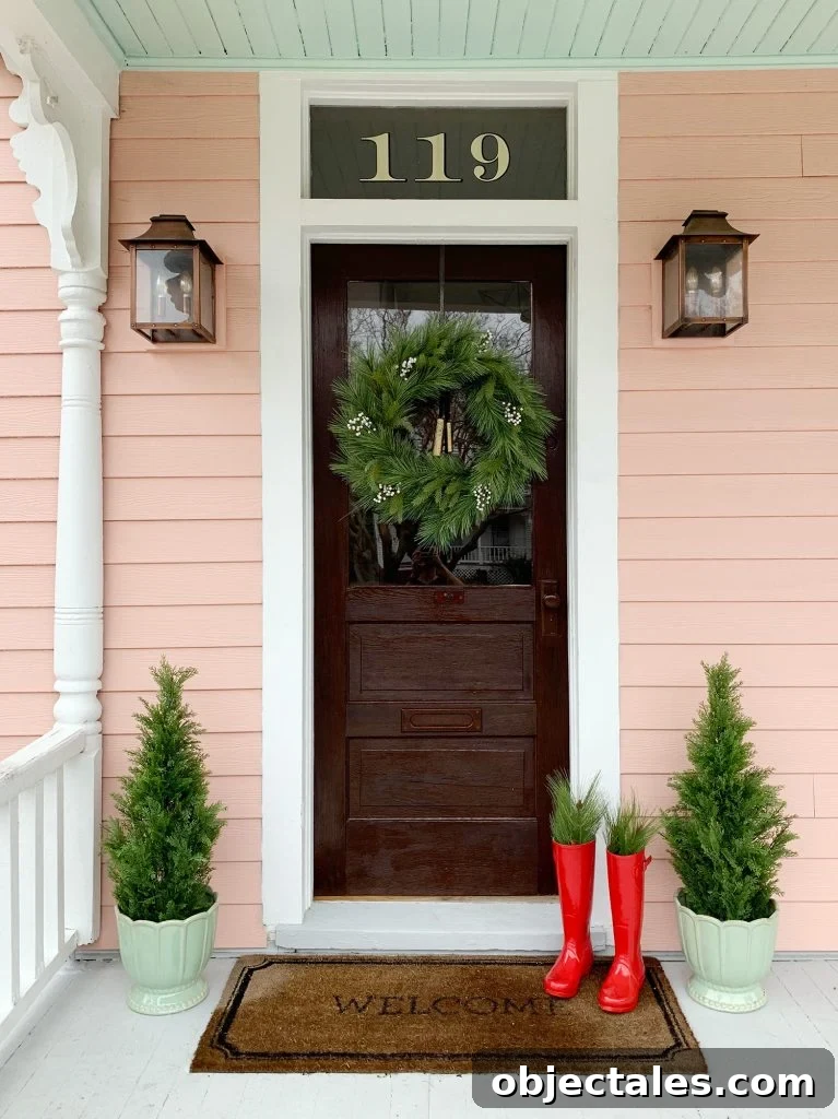Pink House With Wood Door And Faux Christmas Wreath and Faux Trees On Both Sides