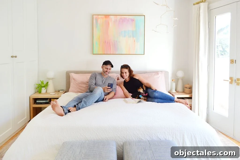 John And Sherry Looking At Phone With Dog On King Size Bed