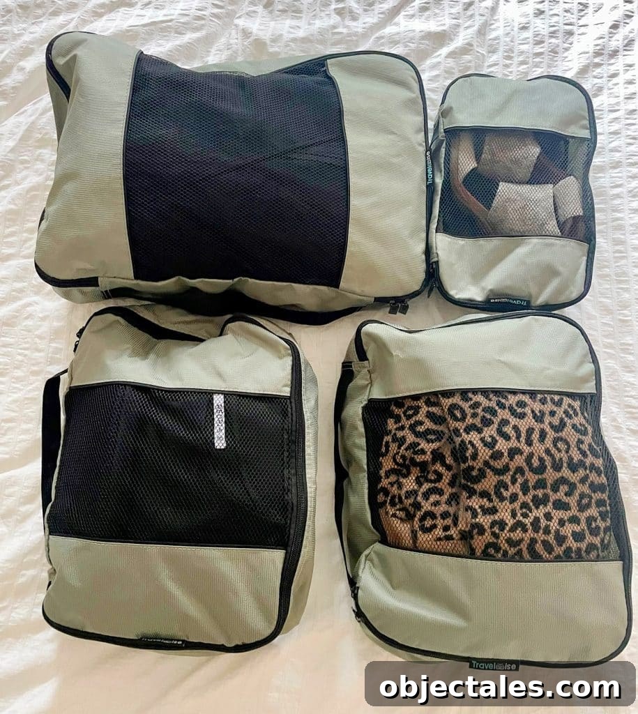 Gray zippered packing cubes on bed with minimal outfits for international trip to France