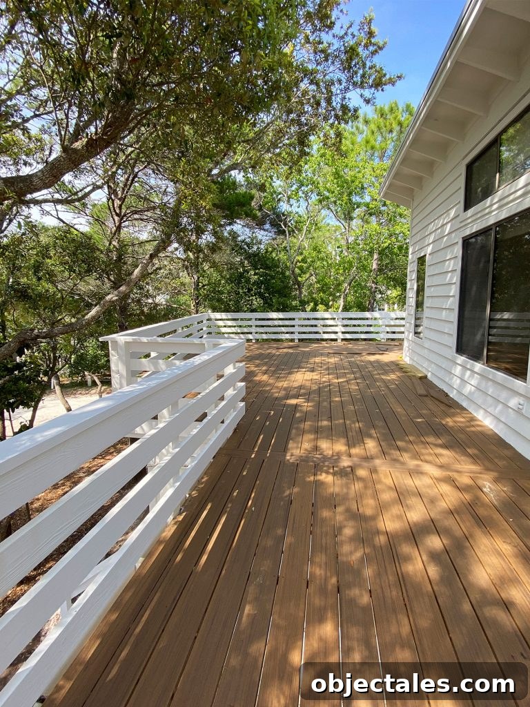 Large outside deck on white house with lots of trees