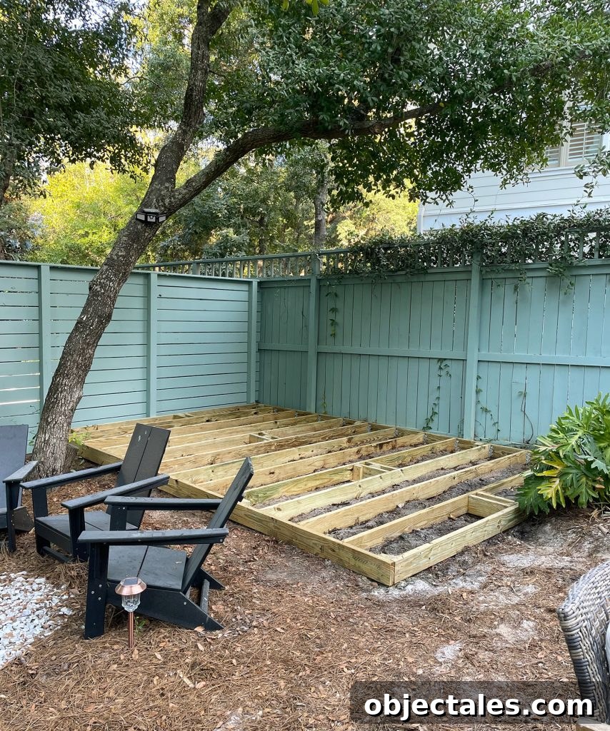 Deck Platform Under Construction In Backyard With Green Fence