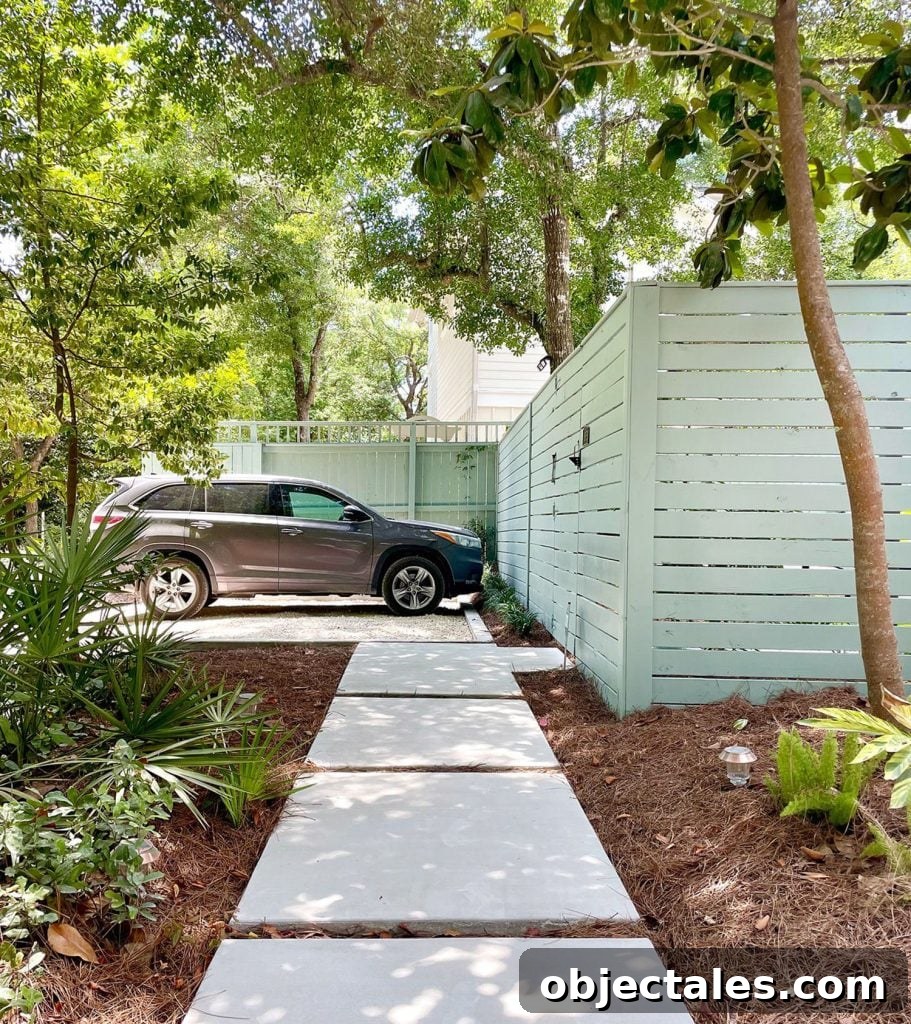 Poured Concrete Walkways and Driveway Installation Guide 2 Gray SUV parked in gravel driveway parking spot with concrete walkway sidewalk