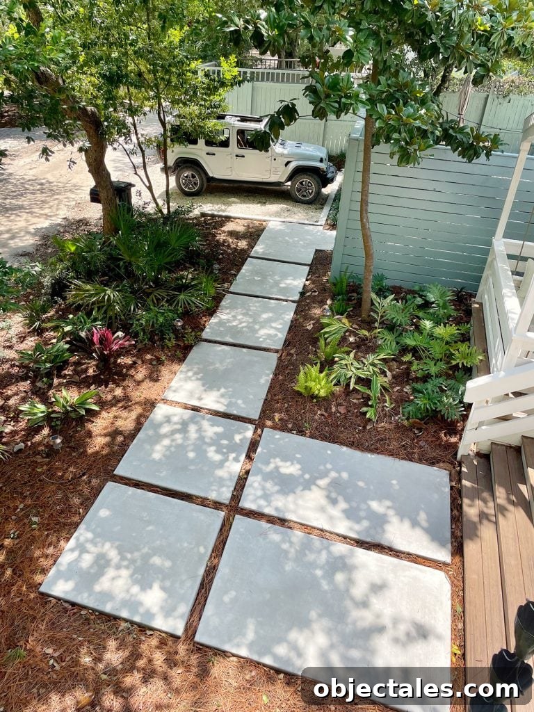 Large paver walkway leading to Jeep parked in gravel driveway