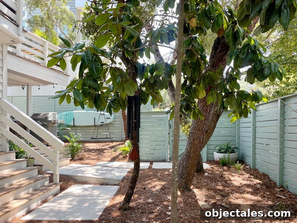 Side Yard With Trees And Steps And Green Fence With Poured Concrete Pavers