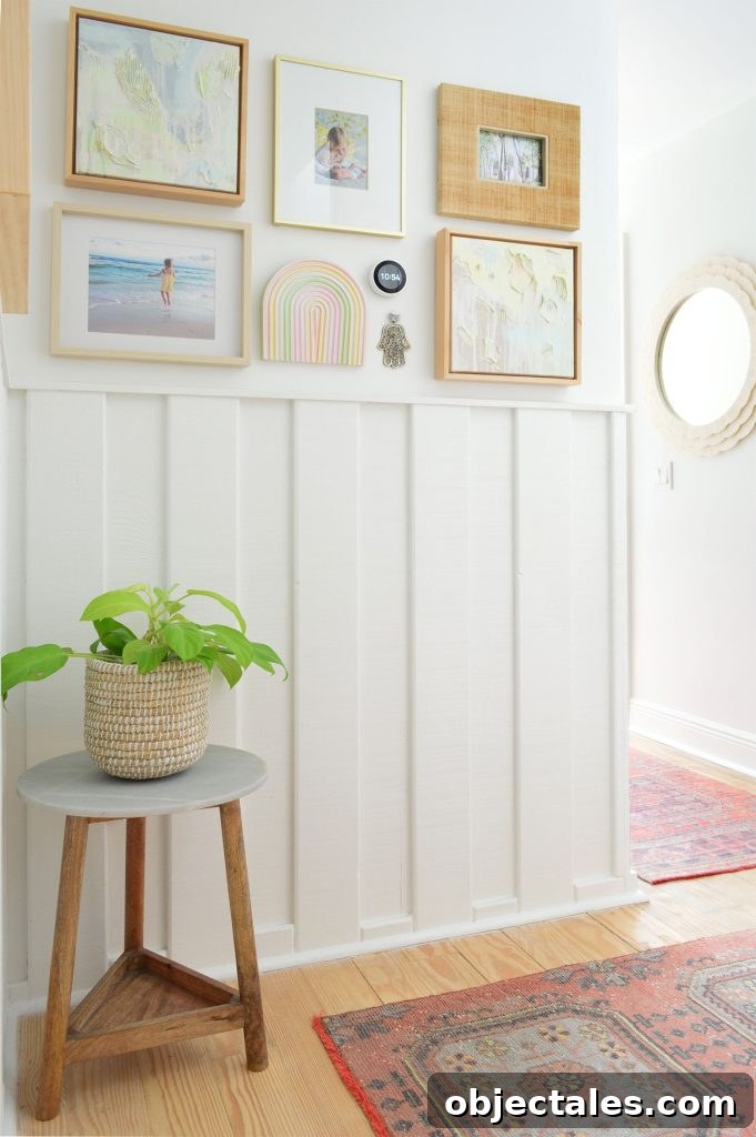 White hallway with wainscoting and picture frame collage and turkish runner rugs