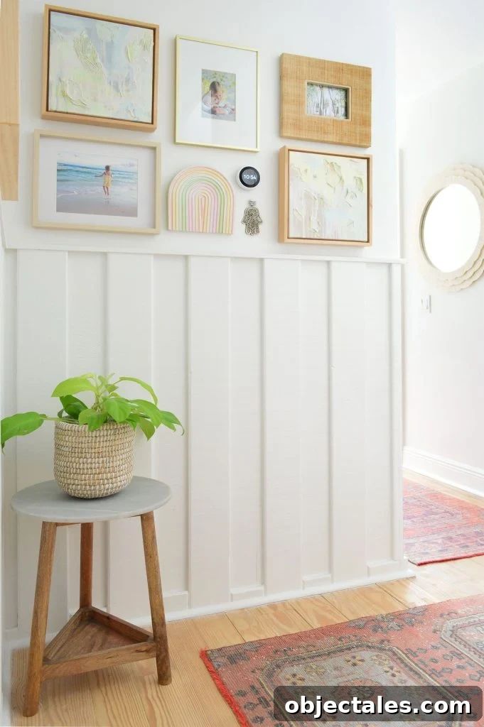 White hallway with wainscoting and picture frame collage and turkish runner rugs