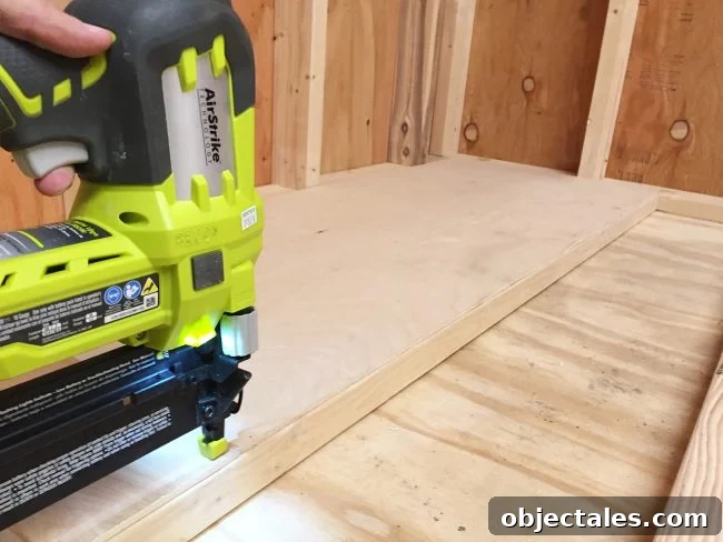 DIY Scrap Wood Storage: Build It From Leftover Lumber 7 nailing plywood panel onto the bottom level of scrap wood storage organizer
