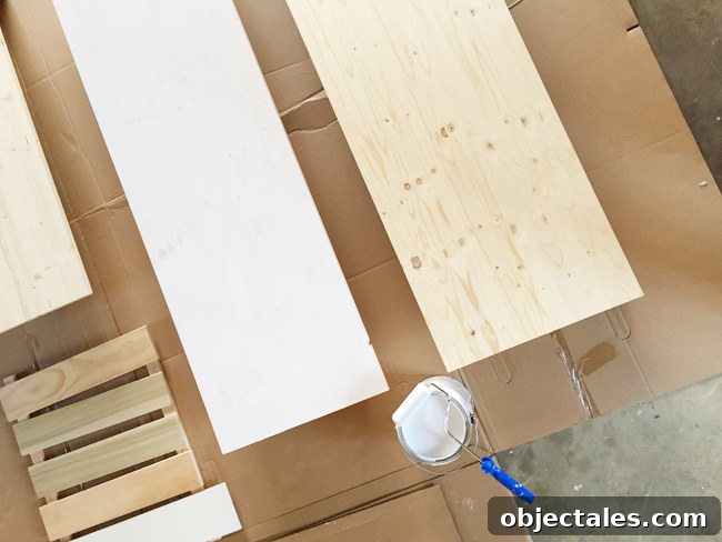 How to Build Custom Built-In Cabinets: Step-by-Step 11 Wood project panels from Lowe's being primed and painted white using a small foam roller for use as countertops