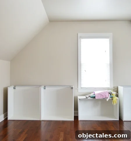 How to Build Custom Built-In Cabinets: Step-by-Step 5 Room with sloped ceiling and Ikea cabinet boxes being built, with a girl's doll using one as a window seat