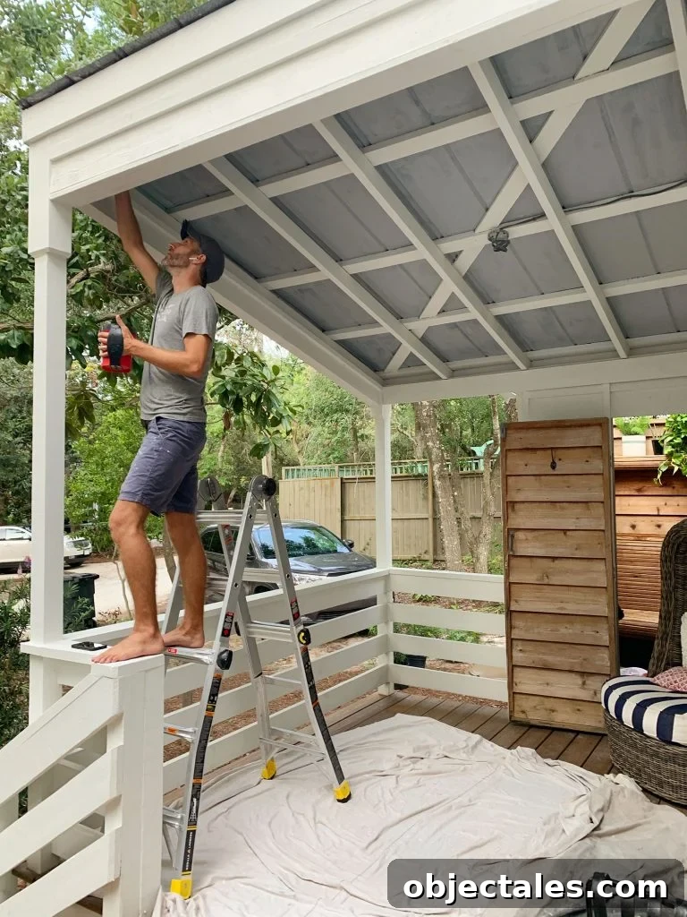 John Standing On Ladder Priming Metal Porch Ceiling