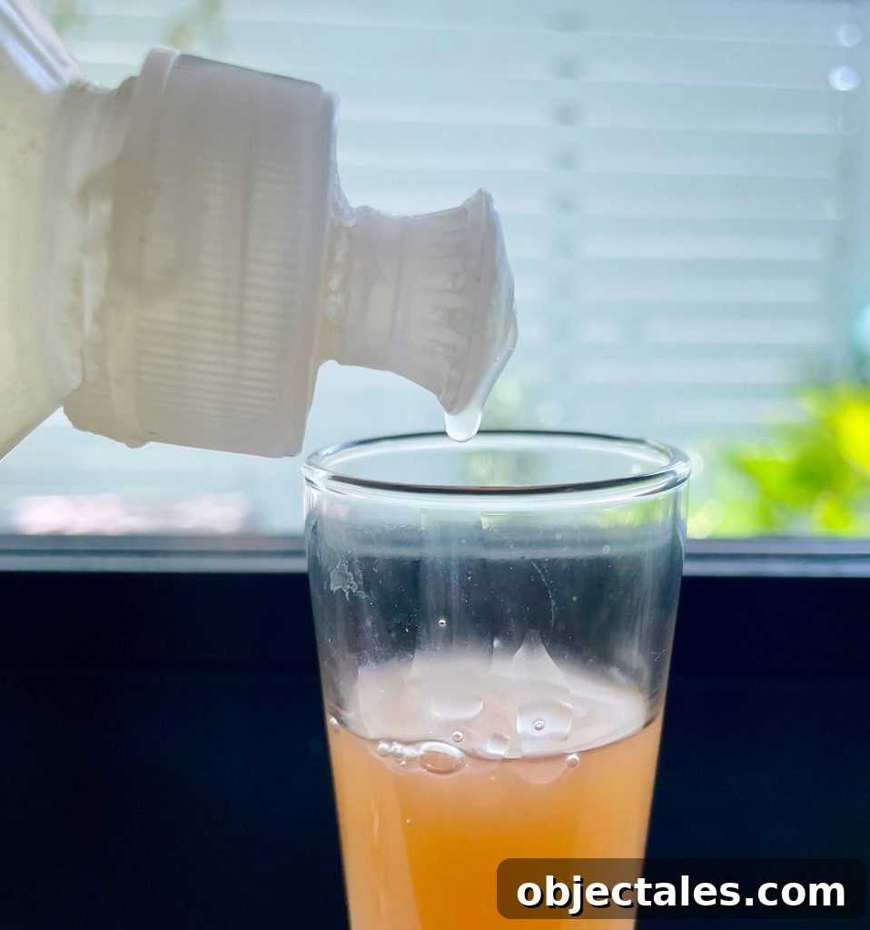 Dripping Dish Soap Into Apple Cider Vinegar For DIY Fruit Fly Trap