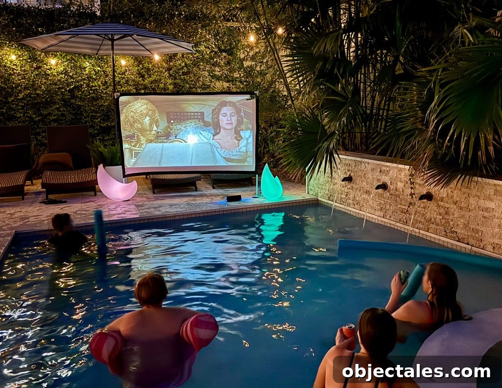 Host an Outdoor Movie Night: Gear Under $200 13 People Watching Movie on Outdoor Screen From Pool