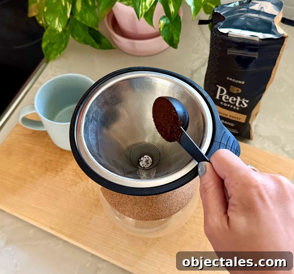 Adding One Scoop of Ground Coffee Into Pour Over Coffee Maker