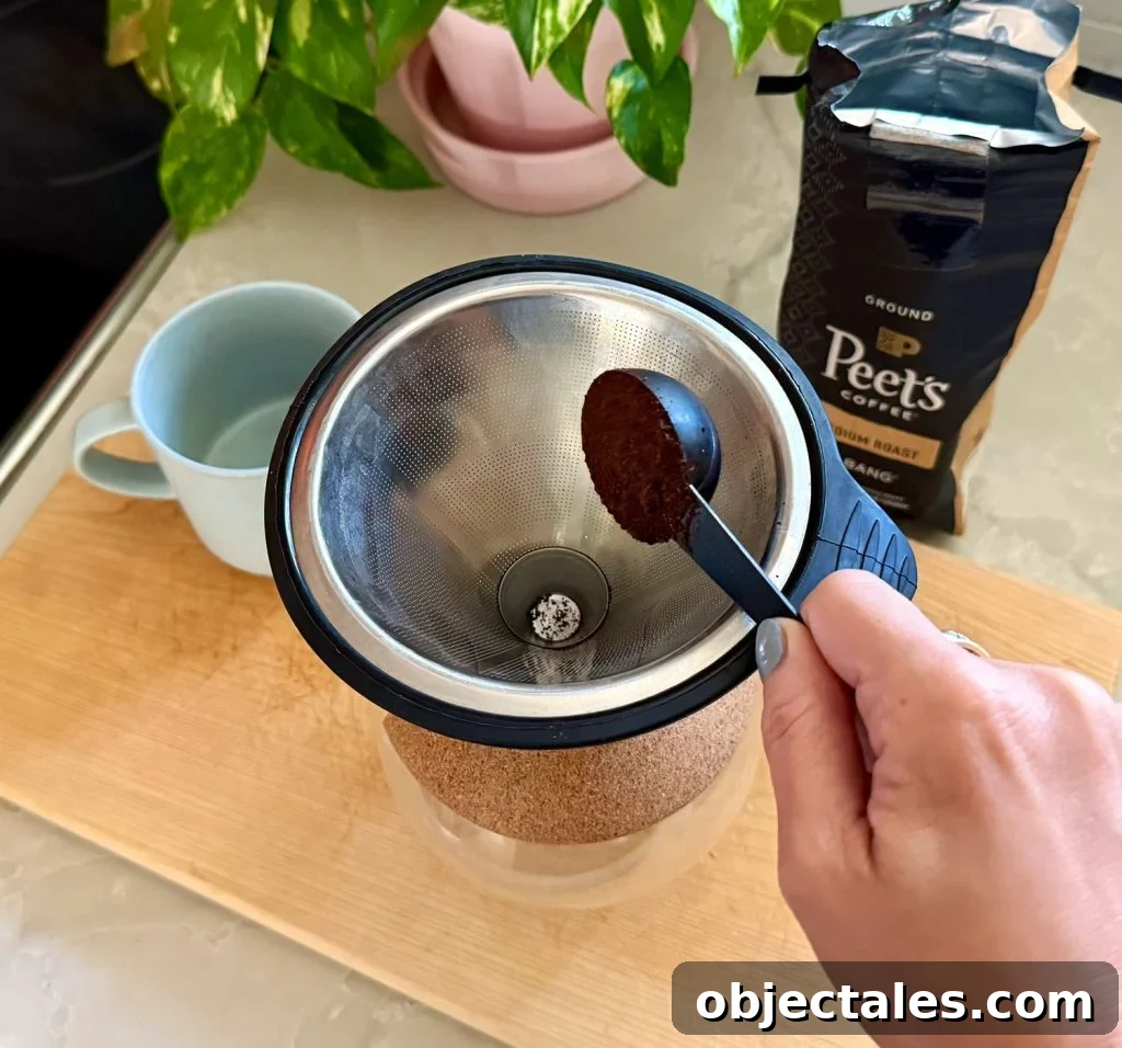 Adding One Scoop of Ground Coffee Into Pour Over Coffee Maker