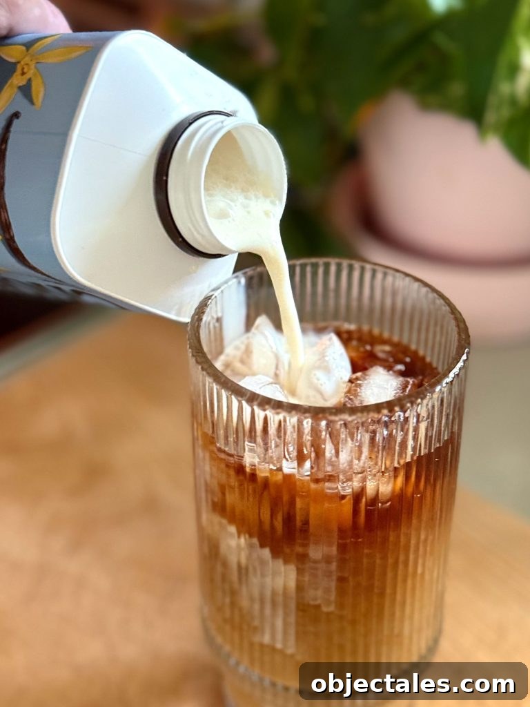 Make Smooth Cold Brew Coffee at Home 11 Pouring Creamer Into Glass of Iced Cold Brew Coffee Made At Home