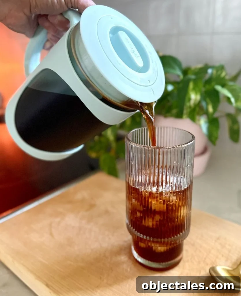 Pouring Homemade Cold Brew Into Glass With Ice