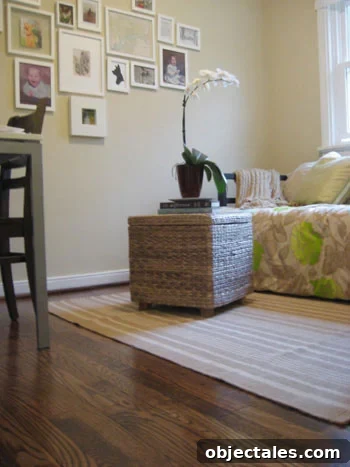 clean hardwood floor with dash & albert striped rug and woven wicker ottoman with orchid