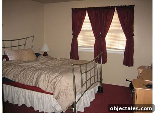 Erin's renovated master bedroom showing bed and coral slipper chair