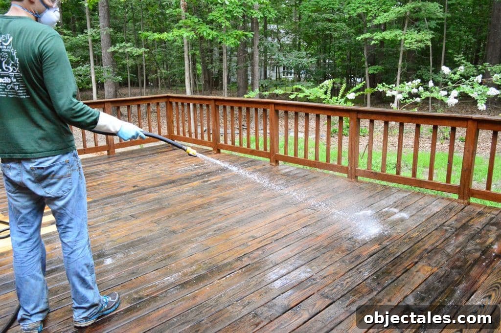 How to Strip a Deck for Staining: Remove Old Finish 16 John rinsing deck cleaner off with garden hose