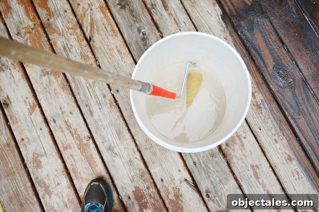 How to Strip a Deck for Staining: Remove Old Finish 9 Dipping paint roller into bucket of deck stain stripper
