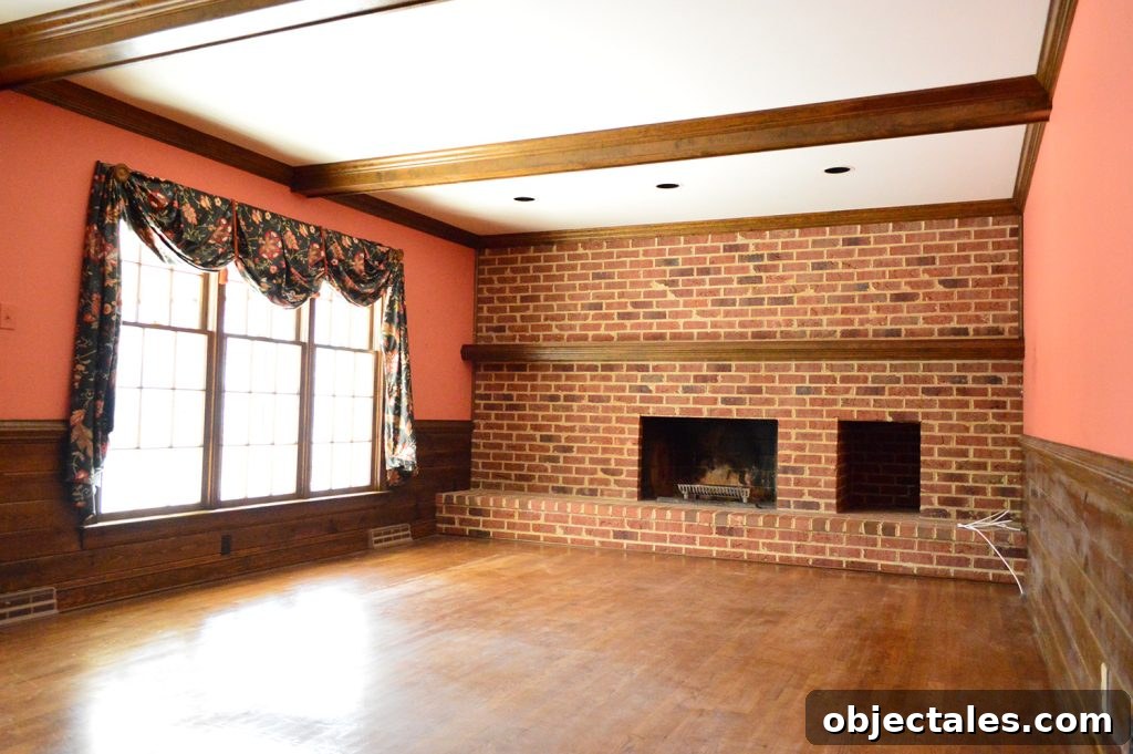 dated 1980s living room with dark brick wall, wood beams, and red salmon colored walls