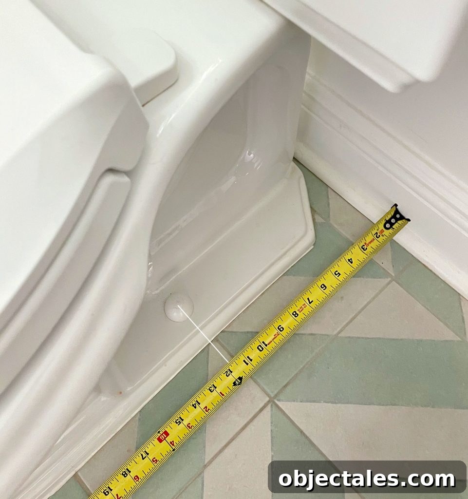 How to Install a Toilet: Step-by-Step Guide for Homeowners 4 Tape Measure Taking Rough In Measurement By Toilet Bowl