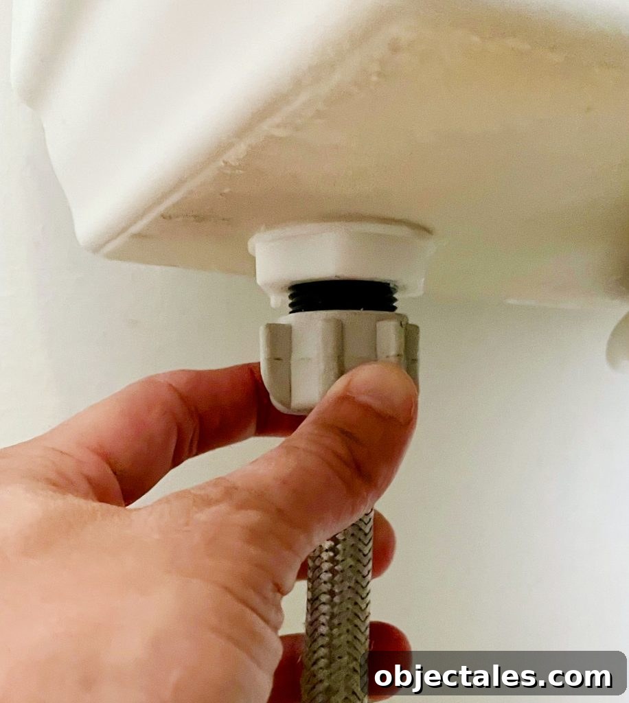 How to Install a Toilet: Step-by-Step Guide for Homeowners 6 Hand Loosening Water Supply Line Under Toilet Tank