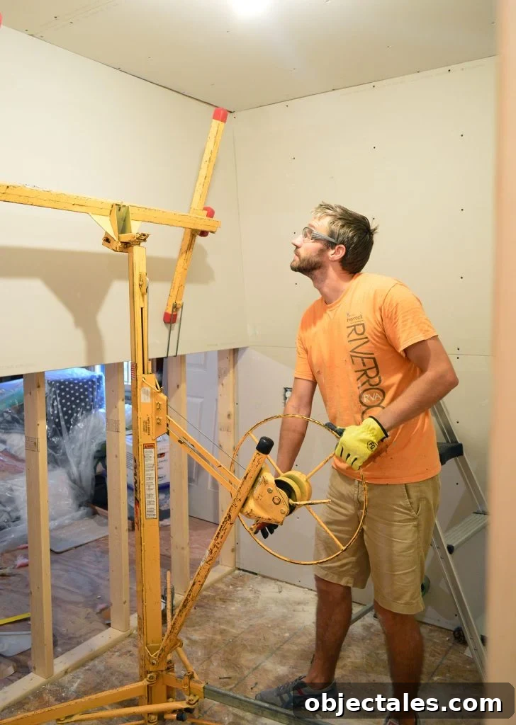 Hang Drywall Alone: Step-by-Step DIY Guide for One Person 2 John lifting drywall panel into place on laundry room wall