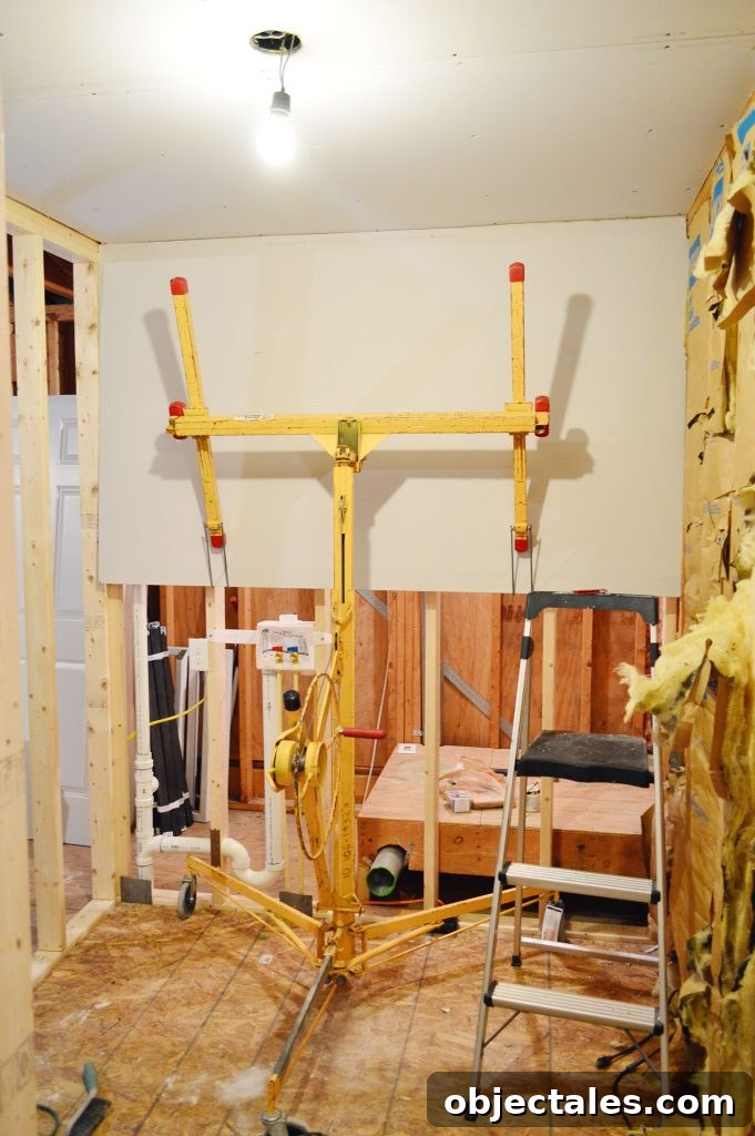 Hang Drywall Alone: Step-by-Step DIY Guide for One Person 10 drywall lift holding sheetrock panel in place against wall